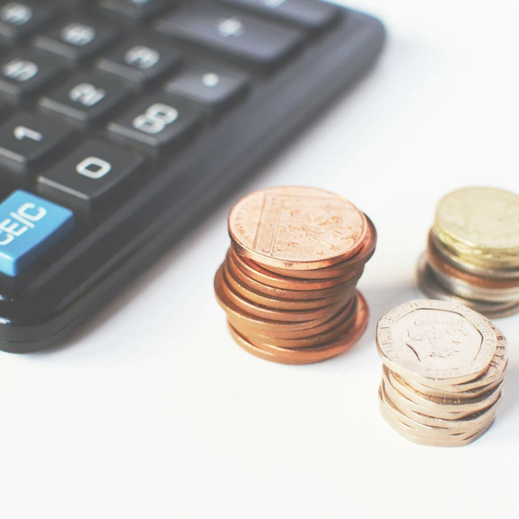 stacks of coins next to calculator